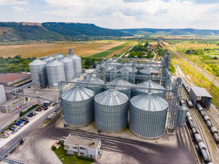 Grain storage facility located in a rural area with large silos and nearby train tracks © DSMT