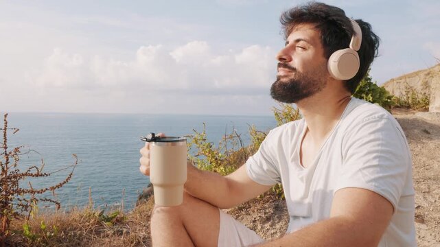 Remote worker relaxing while listening to music over the sea