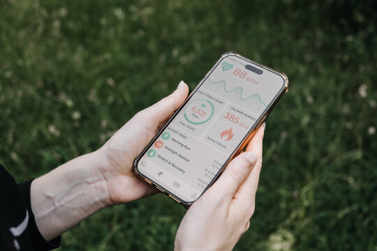 Hands hold smartphone displaying health and fitness application dashboard outdoors. personalized medicine technology, Self tracking health data, quantified self app, health metrics dashboard