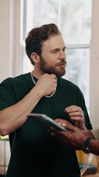 Barber, customer or talk with tablet in shop for beard reference, style suggestion or service. Small business, barbershop or men with tech for grooming consultation, lookbook or planning guard length