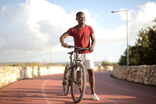Happy young man stands with his mountain bike