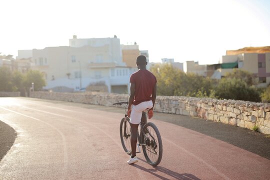 Man with bicycle on a path during golden hour