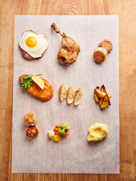 Assorted gourmet dishes with duck, potato, vegetables, and egg, restaurant menu inspiration