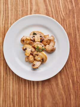 Saut&eacute;ed mushrooms with thyme served on a white plate, perfect for healthy home cooking and restaurant menus