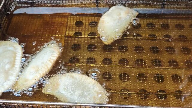 Cooking chebureks in hot oil at a local kitchen