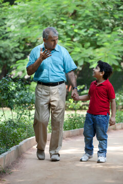 Grandfather and grandson taking a walk in a park