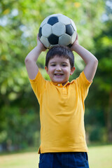 Obraz premium Portrait of a young boy holding a football