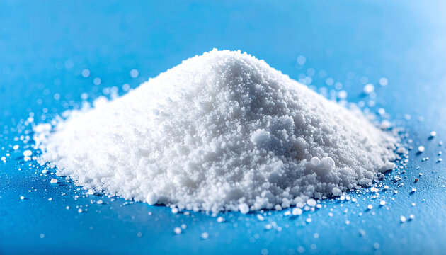 Heap of fine white titanium dioxide powder on smooth blue laboratory surface, scientific composition, chemistry and industrial materials concept. Close-up.