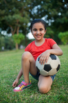 Portrait of a young girl holding a football