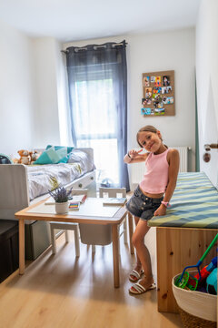 Happy little girl posing in modern bedroom