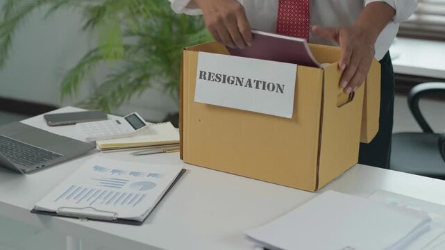 Unemployed businessman packing belongings after resignation