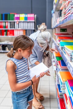 Grandmother and granddaughter shopping for school supplies together
