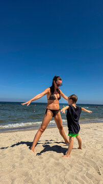 A beautiful woman with a child is exercising on the Baltic Sea coast. Poland.