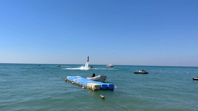 Turkey. 21.07.2026 Man riding flyboard above sea water. Athlete performing water extreme sports with hydraulic jet propulsion. Vacation activity on ocean resort during summer day.
