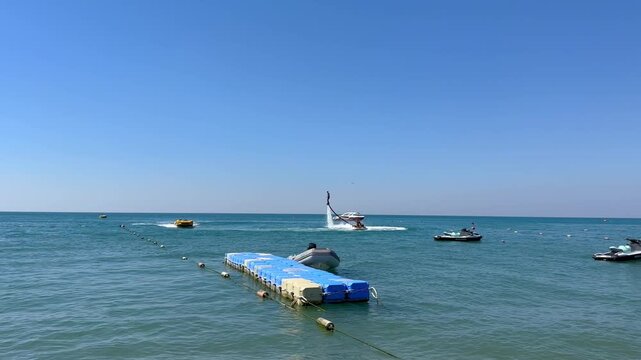 Turkey. 21.07.2026 Man on flyboard hovering above blue sea surface. Water sports enthusiast performing stunt on jet ski in summer. Outdoor recreation and extreme aquatic activity.