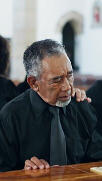 Sad, old man and comfort at funeral with coffin, condolences or memorial service for deceased. Family, console and senior widower with casket at church, final goodbye and burial for farewell ceremony