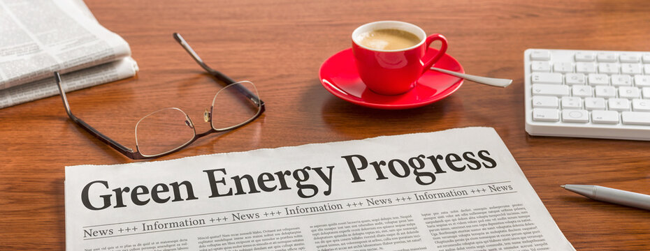 A newspaper on a wooden desk - Green Energy Progress