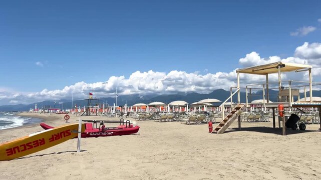 Beach with rows of umbrellas and sunbeds on traditional beach in Viareggio, Lucca, Tuscany Italy.	