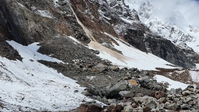 Rocky mountain Chalaadi glacier slope with melting snow and stone debris in Svaneti Georgia, dramatic alpine landscape, geology, environmental change