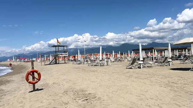 Beach with rows of umbrellas and chairs on traditional beach in Viareggio, Lucca, Tuscany Italy.	
