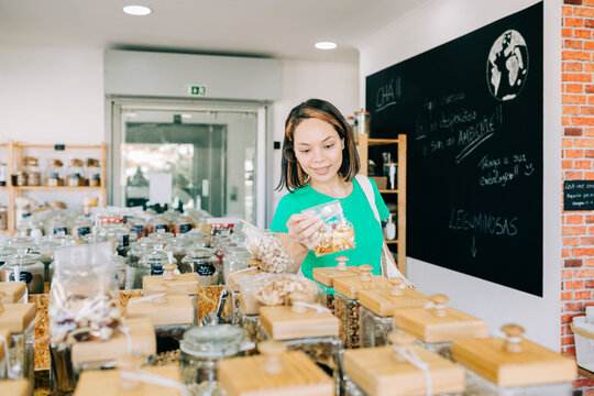 Customer shopping for bulk food in a zero waste grocery store