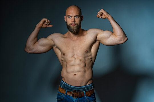 Portrait of a barechested athlete flexing muscles in studio