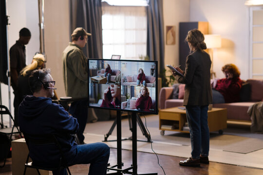 A film director reviews the playback on a monitor with his crew
