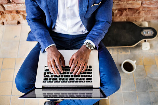 Top view of businessman sitting on longboard using laptop