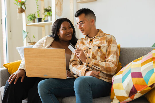 Couple doing online shopping using credit card and laptop at home