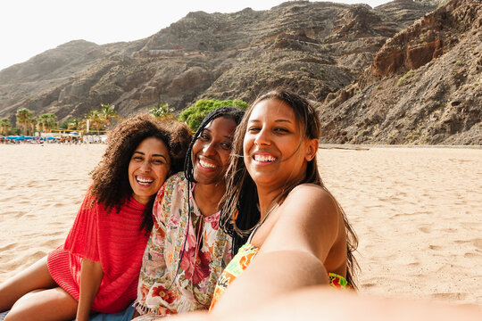 Multiracial young women having fun on the beach during summer vacation - Travel and holidays concept - Main focus on african girl face