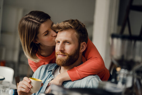 Happy couple embracing at home