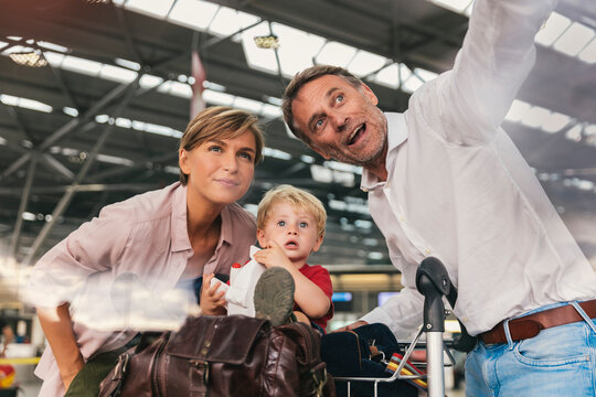 Happy family with baggage cart at the airport