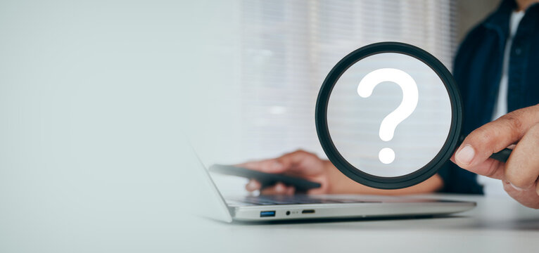 Business Professional holding black Magnifying Glass focused on Question Mark for Problem Solving, Inquiry, Research, Decision Making, Information Search and Customer Support Concept