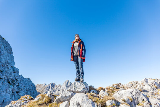 Germany, Garmisch-Partenkirchen, Alpspitze, Osterfelderkopf, female hiker on viewpoint looking at view