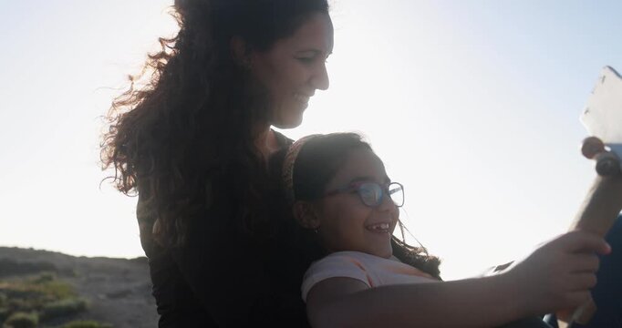 Happy mother having playful time with daughter using wood airplane on the beach - Holiday, summer and family lifestyle concept