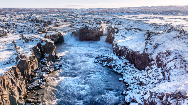 Double waterfall at Aldeyjarfoss, aerial drone shot taken from a high angle. Autumn with snow in the highlands of Iceland.