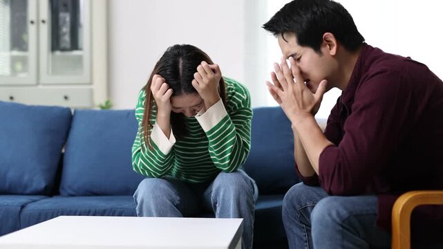 Young couple arguing about financial problems, showing empty wallet and unpaid bills on the table.