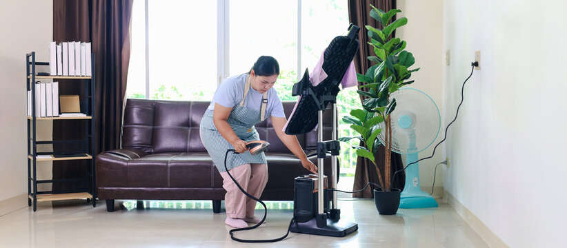 Professional female housekeeper steaming a shirt on a mannequin, representing garment care, ironing, laundry service, housekeeping, clothing maintenance, home cleaning, domestic service,