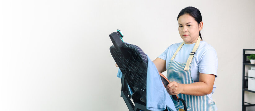 Professional female housekeeper steaming a shirt on a mannequin, representing garment care, ironing, laundry service, housekeeping, clothing maintenance, home cleaning, domestic service,