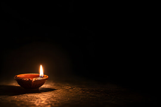 Happy Diwali - Lit diya lamp on street at night. Happy Diwali festival with oil lamp, Diwali holiday Background with rangoli, Diwali celebration greeting card. 3d render