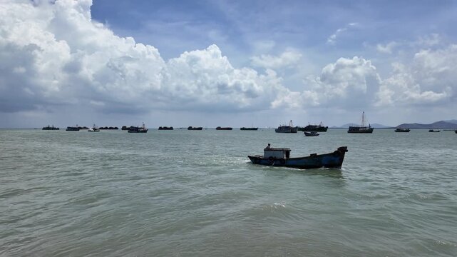 view of sea ferry cruising across Ganh Rai Bay from Can Gio, Ho Chi Minh City to Vung Tau City, Ba Ria - Vung Tau Province, Vietnam, surrounded by busy marine traffic and cargo ships.