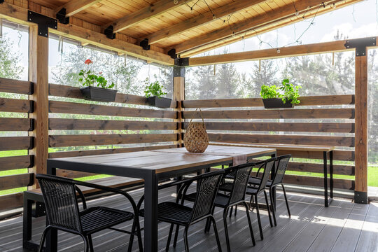 Covered Wooden Terrace with Dining Set and Plants