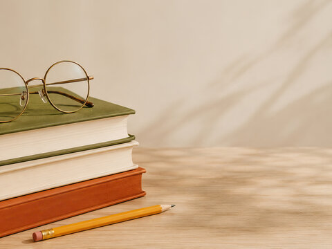 A minimalist image depicting a study scene with stacked books, glasses, and a pencil, conveying a sense of tranquility and focus on learning.