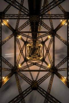 Vista sim&eacute;trica desde abajo de una estructura met&aacute;lica de acero iluminada de noche