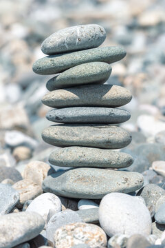 Close-up of balanced stone cairn on rocky shore