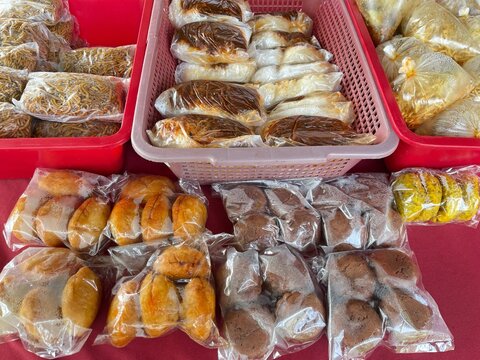 Fresh traditional breads and baked pastries displayed for sale at a local market food stall.