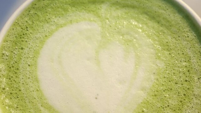 Close up macro shot of frothy matcha latte art with swirling foam, refreshing and healthy beverage.