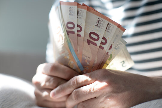 A euro banknote in a man's hand.
