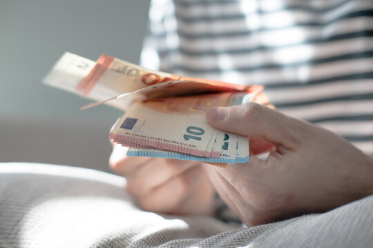 A euro banknote in a man's hand.
