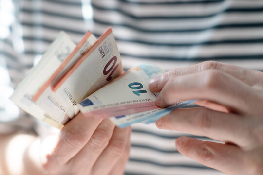 A euro banknote in a man's hand.
